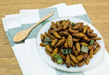 Mutfak ve gıda, Tay geleneksel derin kızarmış Marine Hindistan cevizi solucanlar otlar üzerinde beyaz bir çanak ile. Bir Tayland en popüler sokak gıda.