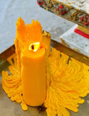 Bir tepsi üzerinde sarı mum ışığı yakma