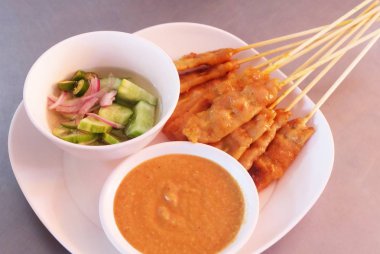 Izgara domuz eti Satay bir tabak salataya salatalık ile