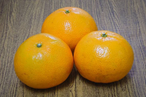 Tres naranjas maduras en una mesa de madera —  Fotos de Stock