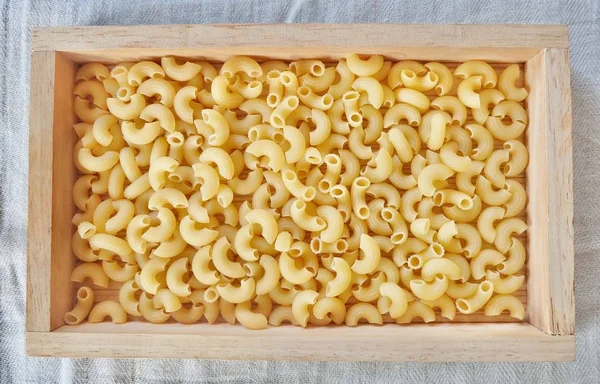 Macaroni au coude séché dans un plateau en bois — Photo