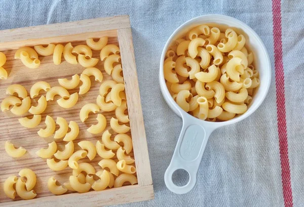 Macarrão de cotovelo seco em um copo de medição — Fotografia de Stock