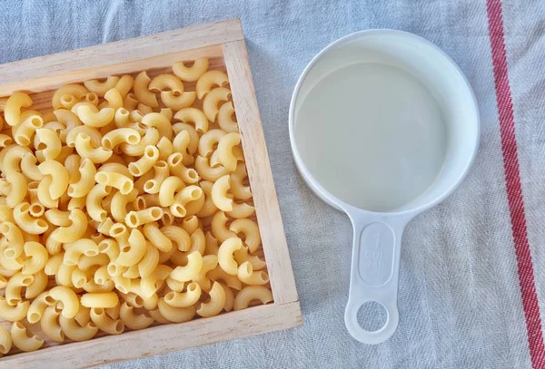 Macaroni au coude séché avec une tasse à mesurer — Photo