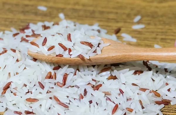 나무 숟가락에 갈색과 흰색 재스민 쌀 — 스톡 사진