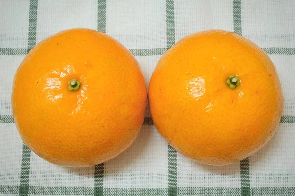 木製のテーブルの上に2つの熟したオレンジ — ストック写真