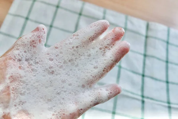 De cerca la mano de la mujer con espuma de burbuja —  Fotos de Stock