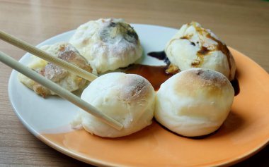 Bir çift çubuk taze ızgara, yumuşak Japon yakimochi 'sini tabaktan kaldırır. Tatlı ve sade soya soslu Asya atıştırmalığı..