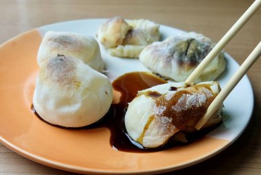 Bir çift çubuk sıcak ızgara yakimochi kaldırır, içi çıtır çıtır ve çiğnenmiş içi olan çok sevilen bir Japon pirinç keki atıştırmalığı. Tatlı ya da tuzlu servis edilebilir..