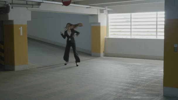 年轻美丽的商业妇女滑稽跳舞和跳跃快乐在地下停车场表达她的幸福 — 图库视频影像