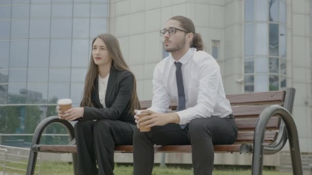 Junge Attraktive Geschäftsfrau Und Geschäftsmann Sitzen Auf Einer Bank Außerhalb — Stockvideo