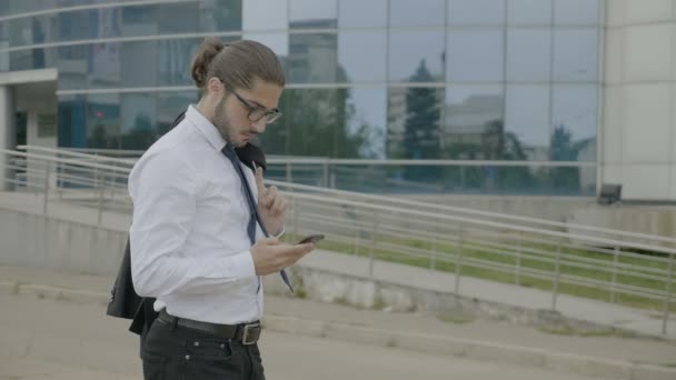 Młody Biznesmen Okulary Kucyk Garniturze Gospodarstwa Kurtka Ramieniu Patrząc Jego — Wideo stockowe