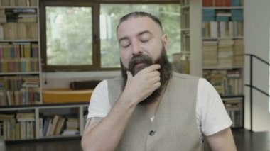 Kendini tutmak için esneme bir adamın yüzünü dokunaklı sakallı uykulu tepki uyanık