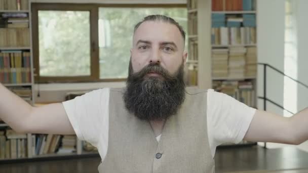 Взорванная реакция молодого привлекательного бизнесмена с бородой, сидящего в офисе — стоковое видео