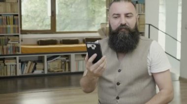 Bir şey okuma ve parmaklarını kullanarak hiçbir onaylamayan jest yapıyor onun smartphone vasıl seyir ofiste iş adamı