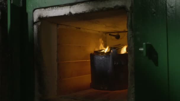 Primer plano de las manos herrero mujer comprobar el aluminio y la llama desde el interior de un horno de reciclaje de fusión y luego cerrarlo — Vídeos de Stock