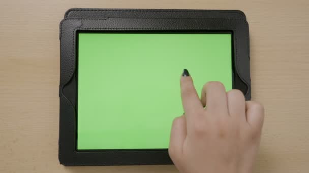 Вид зверху на молоду жінку руки торкаються планшетного ПК зеленого екрану, який переглядає масштабування всередині і зовні — стокове відео