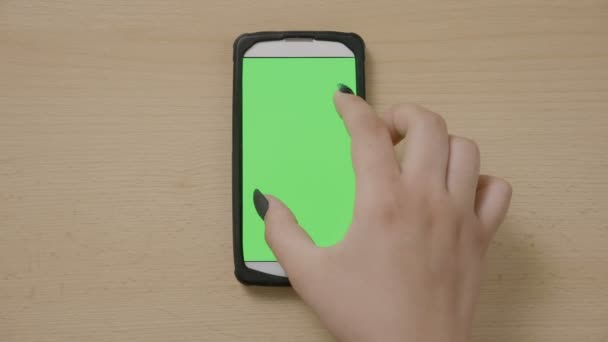 Mulher mão fazendo gestos de zoom rolagem e deslizamento multimídia na tela sensível ao toque do smartphone tela verde — Vídeo de Stock