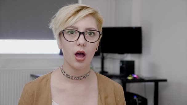 Portrait of surprised employee young woman with glasses sitting at her office — Stock Video