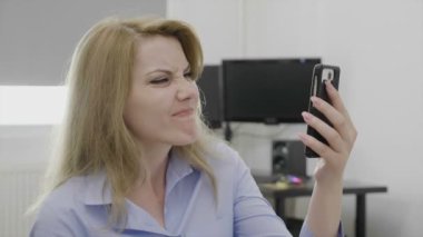 Güzel genç kadın farklı palyaçoluk ve tepkiler o dalga köpüğü online sırasında gösterilen internet üzerinden online alışveriş için smartphone kullanarak iş başında