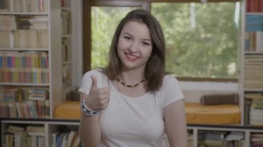 Giyimli genç girişimci kadın rahat işaretleme başparmak yukarıya için onay ve iyi iş işareti