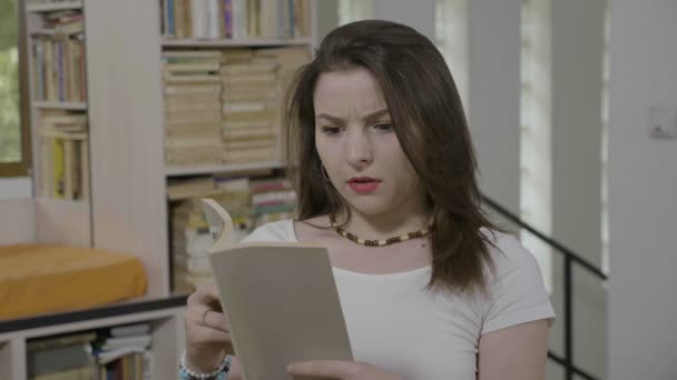 Mujer Estudiante Sonriente Relajarse Biblioteca Disfrutando Lectura Libro Interesante Expresar — Vídeos de Stock