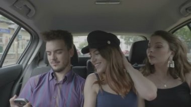 Taksi uber araba ile sohbet ve birlikte gülüyor şehir yolculuk zevk içinde yolcu koltuğuna oturan üç genç arkadaş