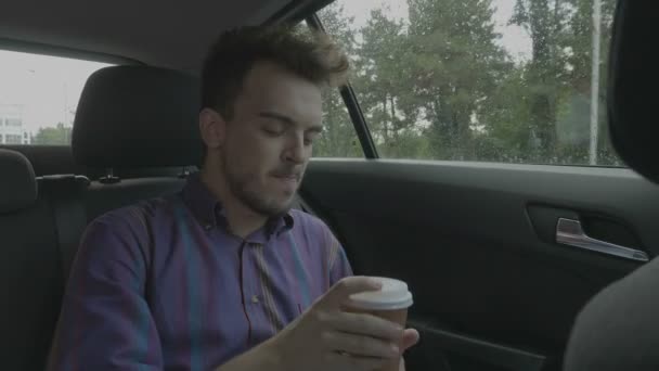 Young Man Holding Cup Coffee Standing Backseat Uber Taxi Car — Stock Video