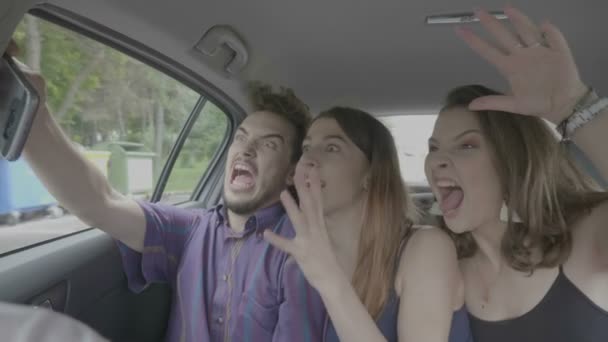 千年一代的疯狂朋友们在车内拍摄自拍飞镖视频 他们在智能手机摄像头前尖叫着鬼混 — 图库视频影像