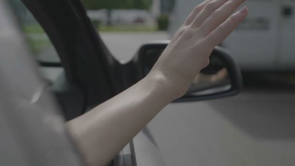 Sorglös Ung Kvinna Vinka Hennes Arm Utanför Flyttar Carwindow — Stockvideo