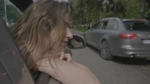 schöne lächelnde Teenager-Mädchen, die auf eine Reise gehen, lehnt sich aus dem Fenster Auto Ausdruck der Freiheit Spaß und Glück