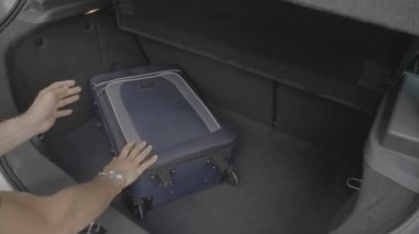 Genç adam acele acele seyahat çantaları ile araba bagajında yükleme eksik uçuş hakkında endişeli