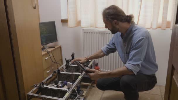年轻技术人员在 平板电脑应用上安装 Gpu 采矿钻井平台 测量电能消耗并调整数据 — 图库视频影像