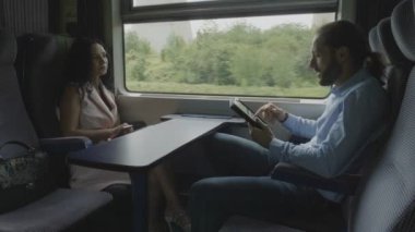 Genç iş adamı konuşuyor ve seyahat sırasında zarif çekici genç kadınla flört tablet pc kullanarak ev işten commuting