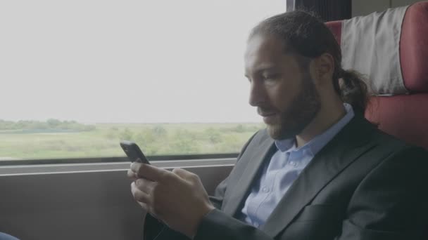 Młody Przedsiębiorca Człowiek Podmiejskim Pociągu Siedzący Obok Okna Pomocą Smartfona — Wideo stockowe