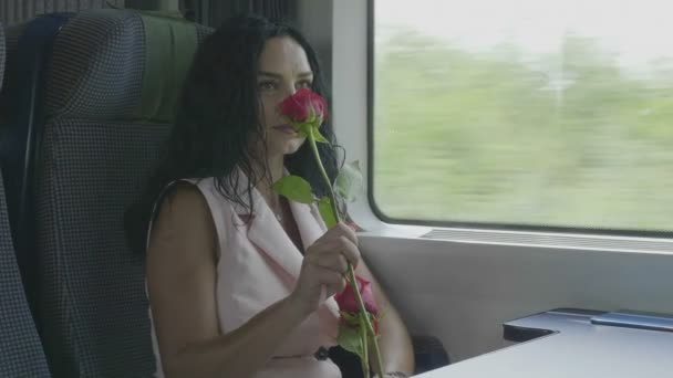 浪漫优雅的女人站在窗边闻玫瑰旅行火车浪漫之旅的概念 — 图库视频影像