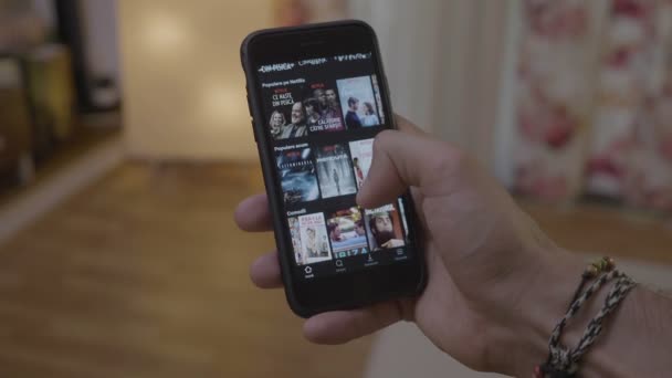 スマート デバイスのデータベースのオンライン映画テレビ番組エピソードの検索表示に彼の指でページをスクロール上の Netflix アプリを参照して千年の男 — ストック動画
