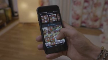 Genç adam smartphone ekran fotoğraf düzenleme ve onları sosyal medya ağ instagram üzerinde paylaşım düzen app tarama yazarak el