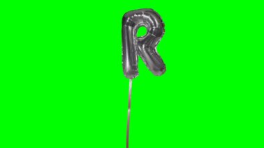 Alfabe gümüş helyum balon yüzen gelen harf R üstünde yeşil perde