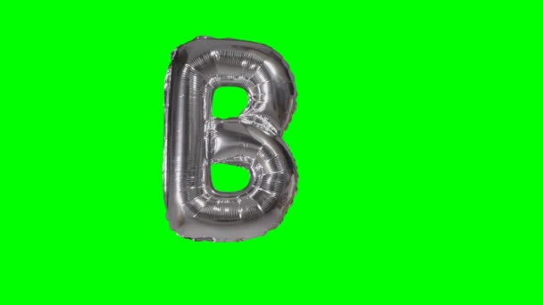 緑色の画面に浮かぶアルファベット シルバーのヘリウム風船から大きな文字 — ストック動画