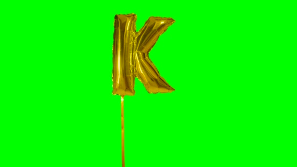Dopis K abeceda helium zlato bubliny plovoucí na zelené obrazovce
