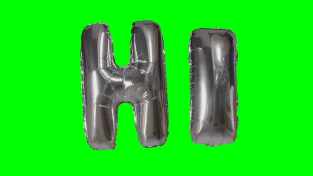 Word hi from helium silver balloon letters floating on green screen — Stock Video