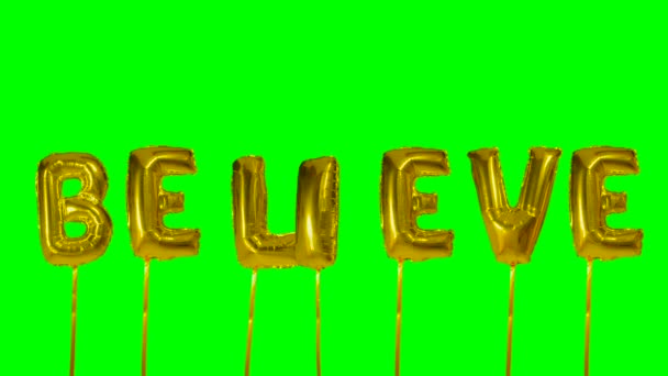 緑色の画面に浮かぶ黄金のヘリウム風船文字から単語を信じてください。 — ストック動画