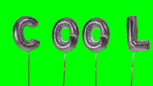 Word cool uit zilveren helium ballon brieven drijvend op groen scherm — Stockvideo