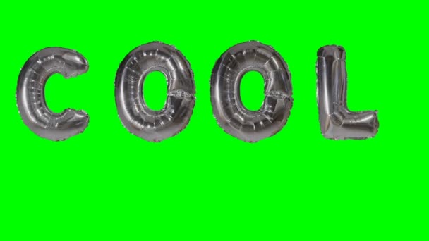 Word cool uit zilveren helium ballon brieven drijvend op groen scherm — Stockvideo