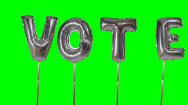 Word vote from helium silver balloon letters floating on green screen — Stock Video