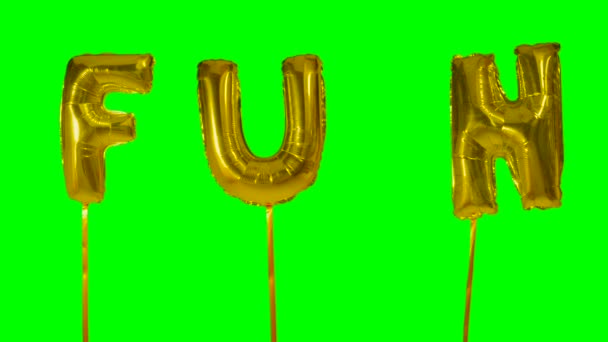 Word fun from helium golden balloon letters floating on green screen — Stock Video