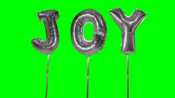 Слово радість від гелієвої срібної кулі літери, що плавають на зеленому екрані — стокове відео