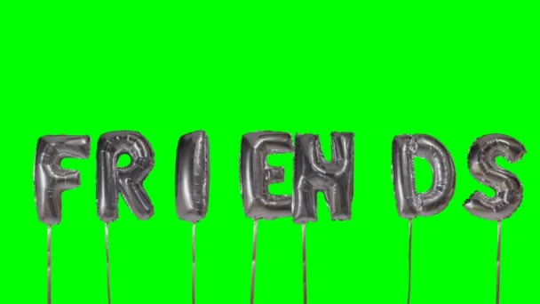 Word friends from helium silver balloon letters floating on green screen — Stock Video