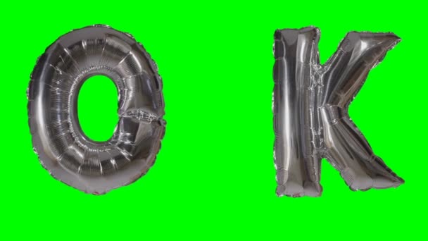 Word ok uit zilveren helium ballon brieven drijvend op groen scherm — Stockvideo