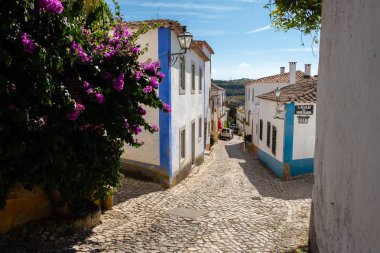 Obidos, Portekiz - 21 Eylül 2018: Portekiz merkezi tarihi köyün duvarları içinde dar sokakları ve renkli evler Leiria, Portekiz